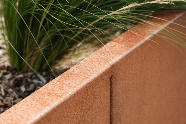 Corten steel, also known as weathering steel, serves as a staple in landscape architecture. Its distinctive, rusted appearance creates a unique aesthetic that blends seamlessly with natural environments although Corten run-off can be a concern.